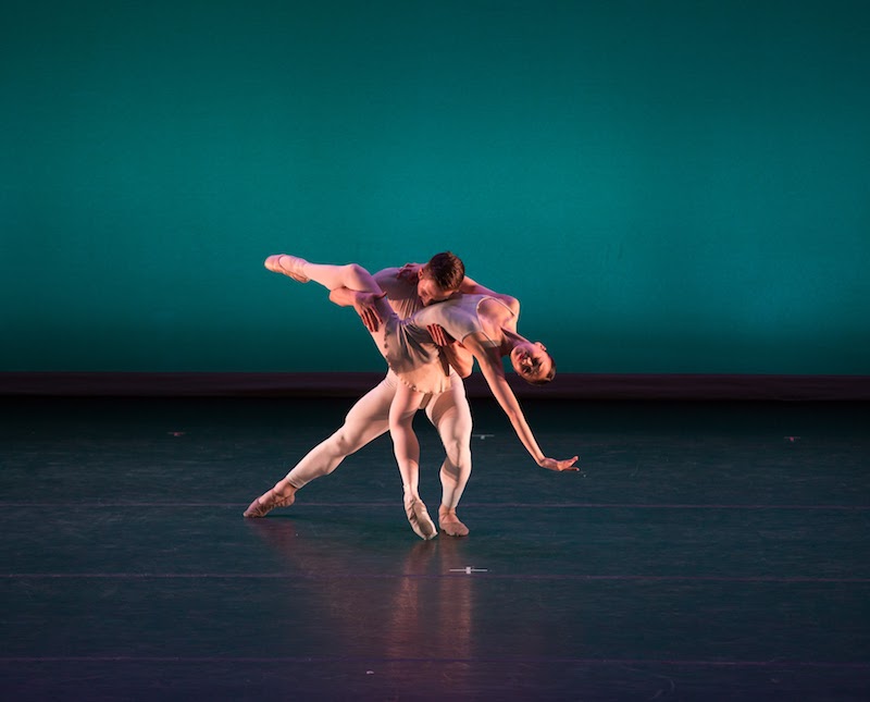 A woman executes a dramatic back bend on demi pointe while her partner lays his head on her chest